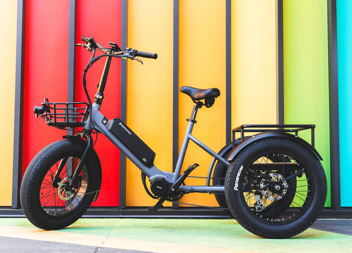 Surface 604 Trio Folding eTrike in front of multi-color wall.