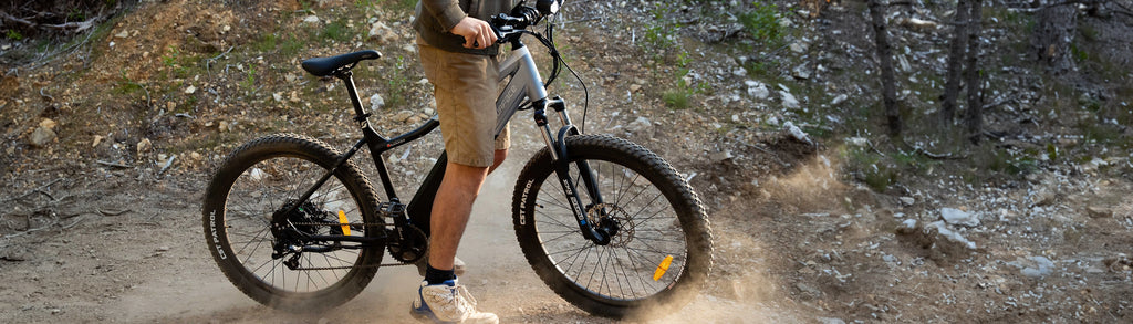 Person standing with a Surface 604 eBike on a dirt pathway