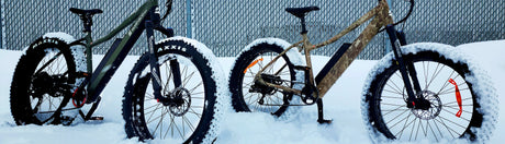 Two Calgary eBikes parked next to each other on patch of deep snow