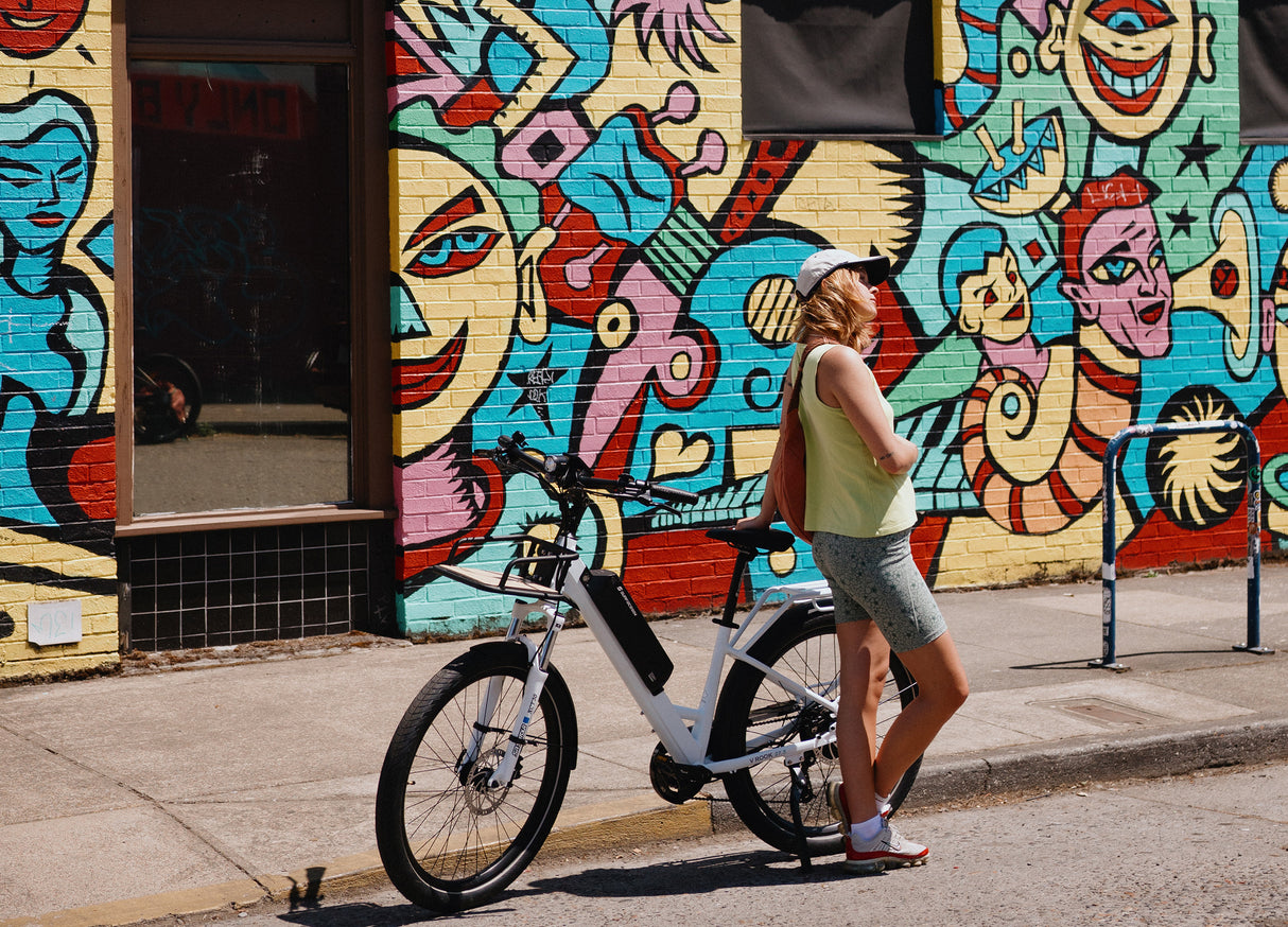 SURFACE604 - V Rook Low Step 500W Commuter parked in front of graffitied building.